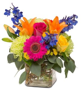 hot pink daisy orange lilies and purple stock with greenery in cube vase