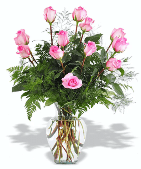 One dozen hand-picked pink roses arranged in a clear glass vase with a variety of greenery.